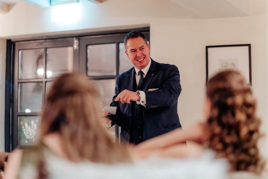 The Gentleman Pickpocket performing an after-dinner magic show for a small seated group