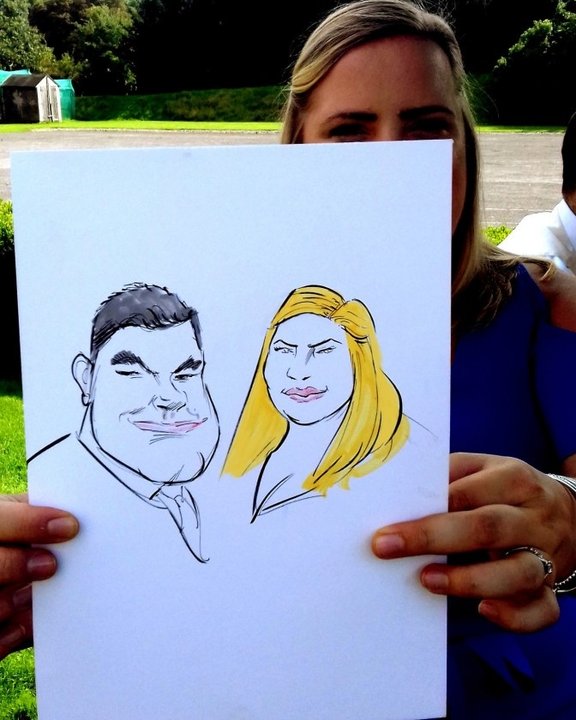 Wedding guest holding a couple caricature outdoors