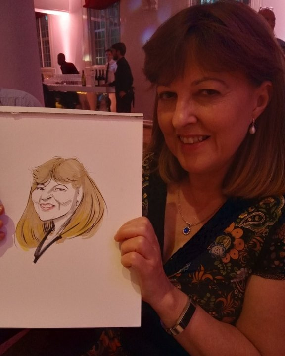 Guest holding her colour caricature at an evening party