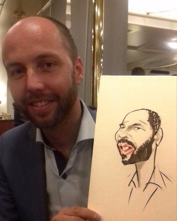 Guest holding his caricature at a corporate party