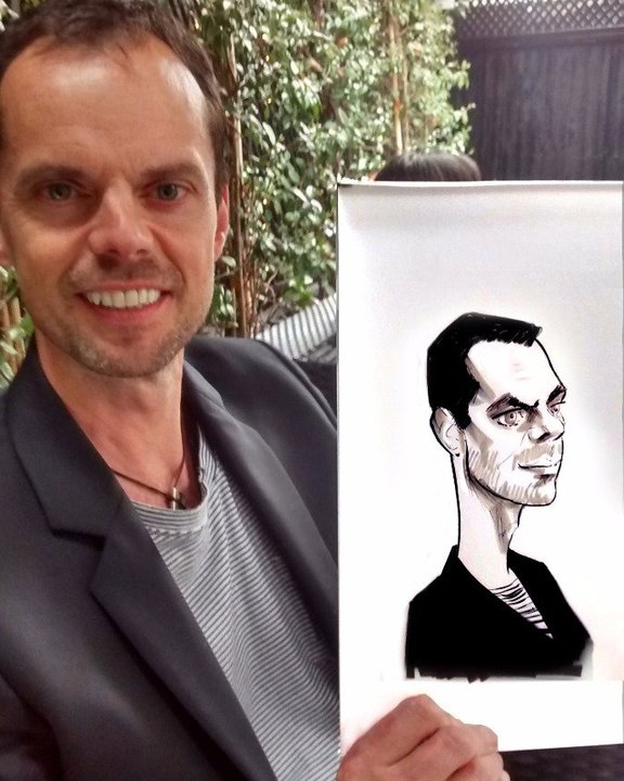 Guest holding his caricature at a garden event