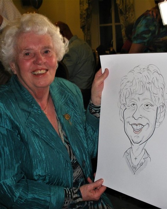 Guest at an 80th birthday party holding her live caricature
