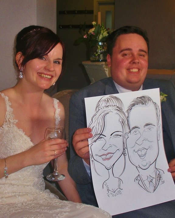 Bride and groom holding their live wedding caricature