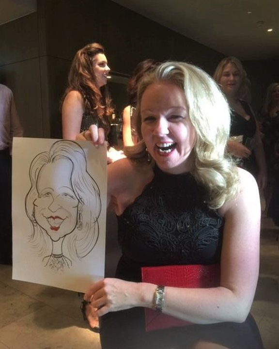 Guest laughing with her caricature at an evening party