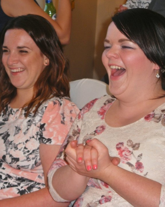Two guests laughing at the reveal of their caricature