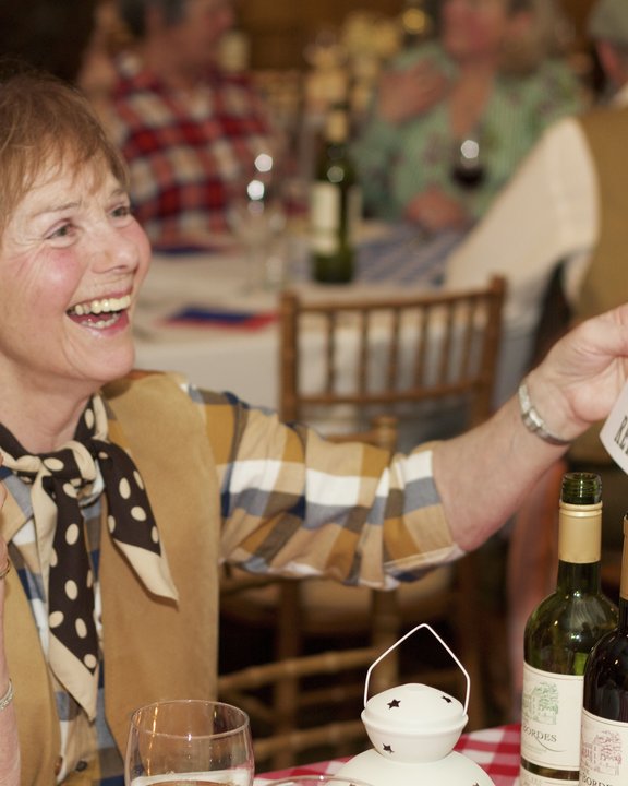Guest laughing at her wanted-poster caricature at a Western party