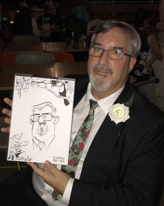 Wedding guest with a buttonhole holding his caricature