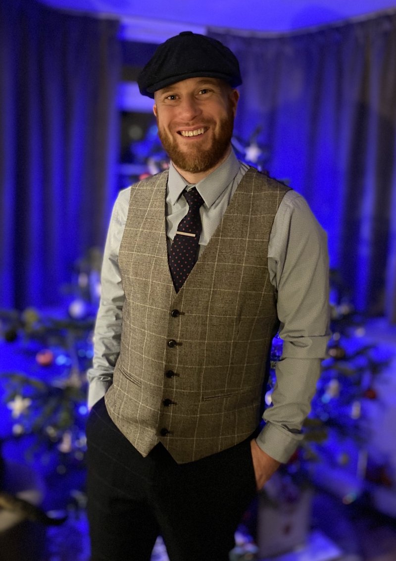 Jolly Caricatures artist in a flat cap at an evening event