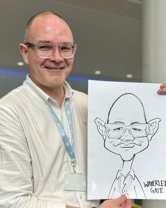 Delegate holding his caricature at a corporate event