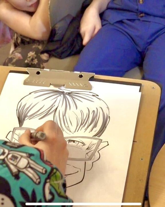 A caricature being drawn live on a clipboard