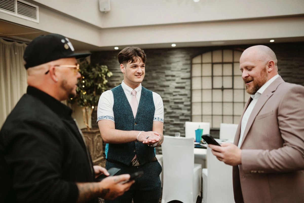 The magician performing a card trick for two wedding guests