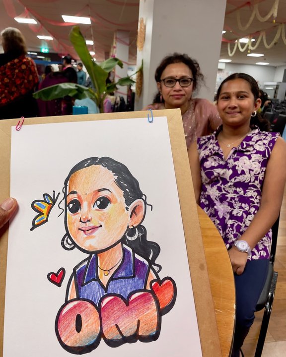 Mother and daughter beside a colour caricature of a young girl at a celebration