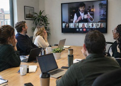 Office team watching a virtual magician perform on the meeting room screen